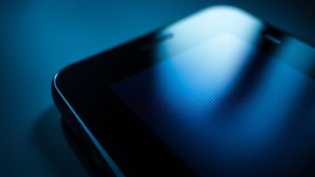Macro photograph of a smartphone AMOLED display showing the pixel grid under studio lighting