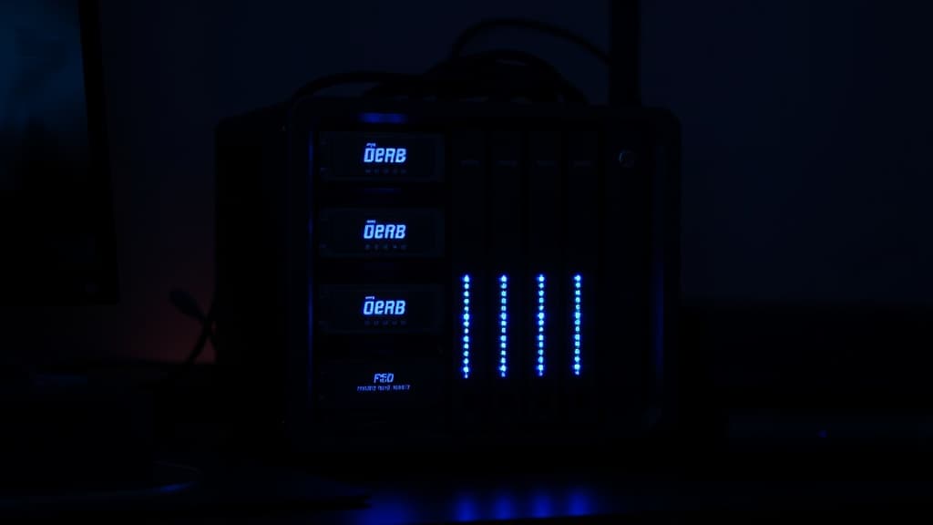 Custom NAS server build with hard drives and blinking status LEDs in a home office
